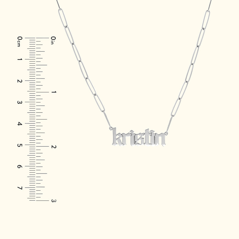 Silver necklace with the name "kristin" in decorative lettering. Ruler for scale included.