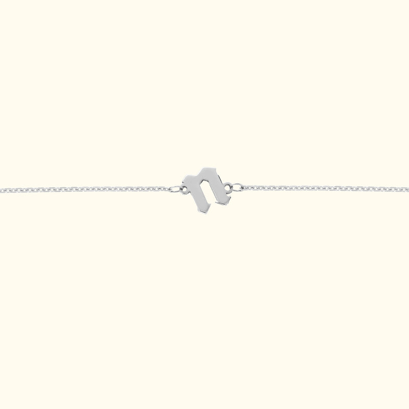Minimalist silver bracelet featuring a geometric clasp on a light background.