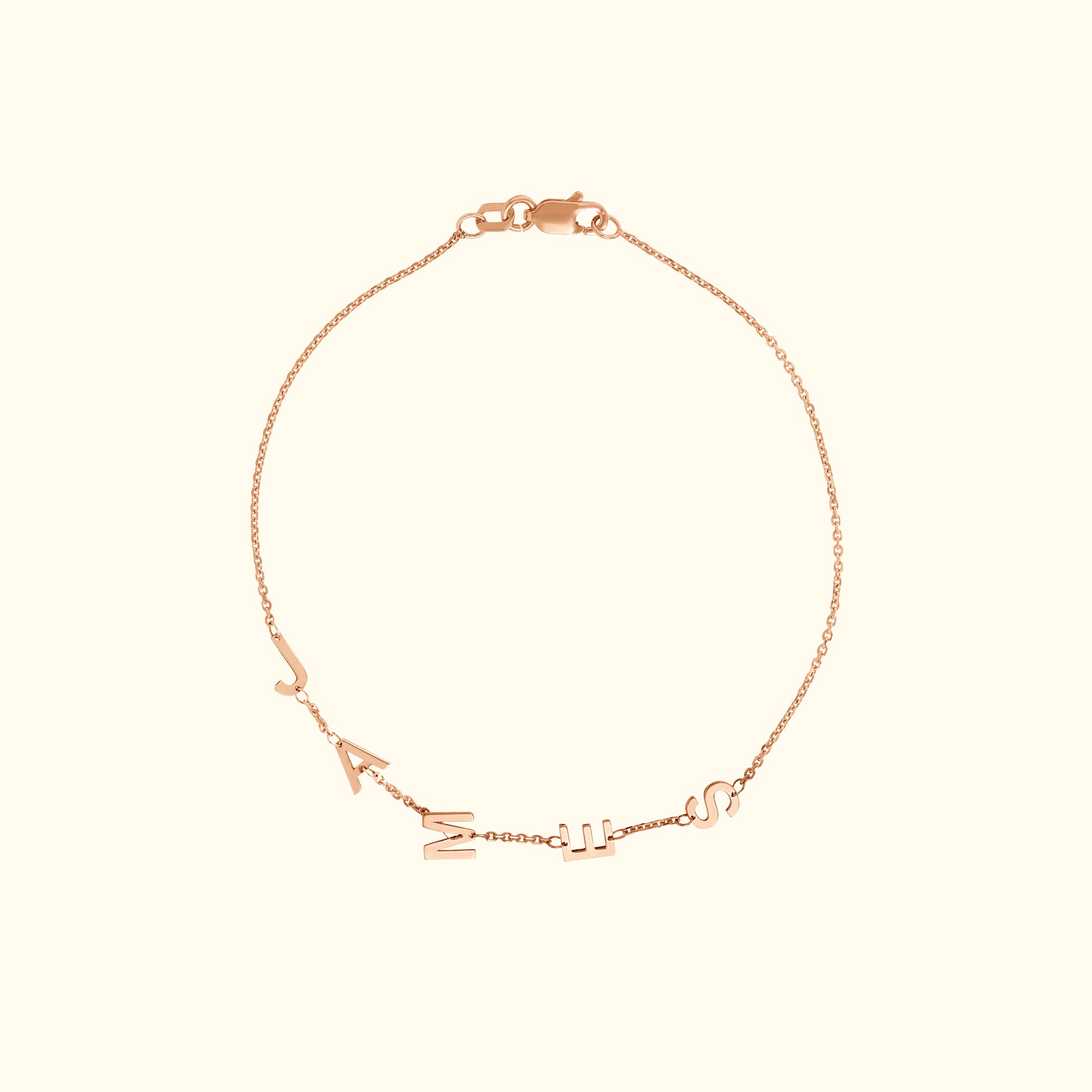 Delicate rose gold bracelet with hanging letter charms.