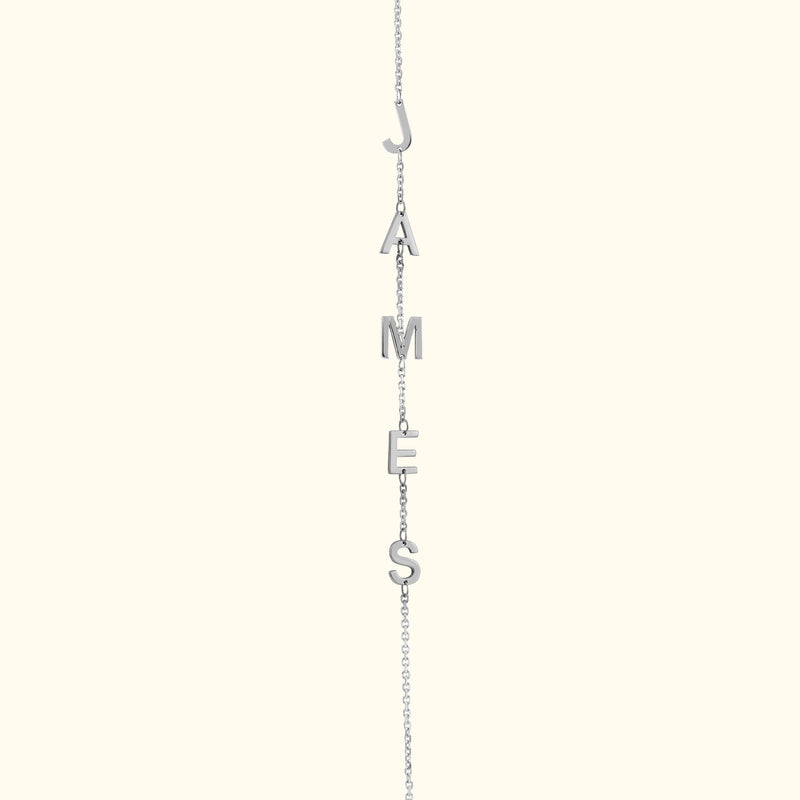 Silver necklace featuring the letters spelling "JAMES."