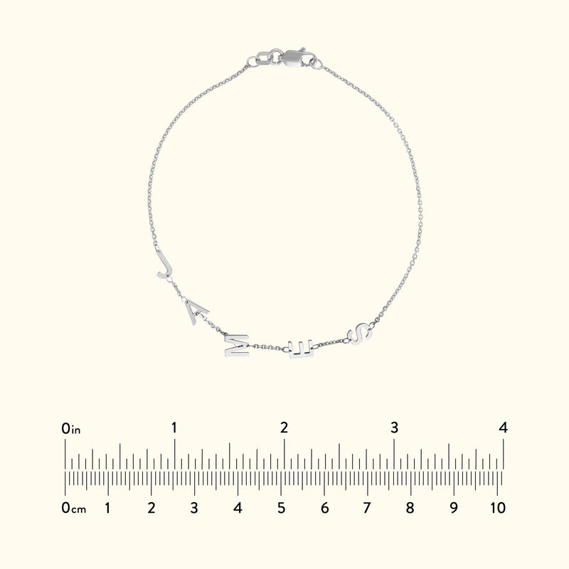 Silver chain bracelet with letter charms, displayed over a light background.