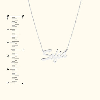 Silver necklace with the name "Sofia" in cursive lettering, displayed with a ruler for scale.