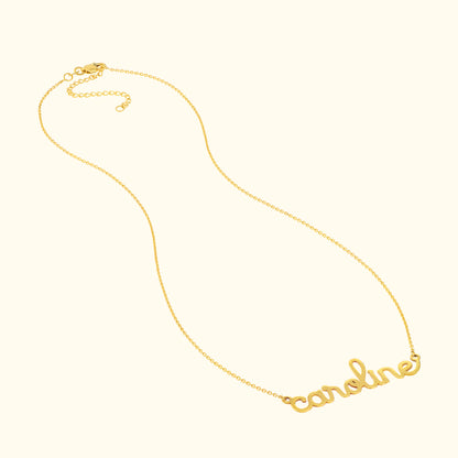 Gold necklace with the name "caroline" in cursive lettering.