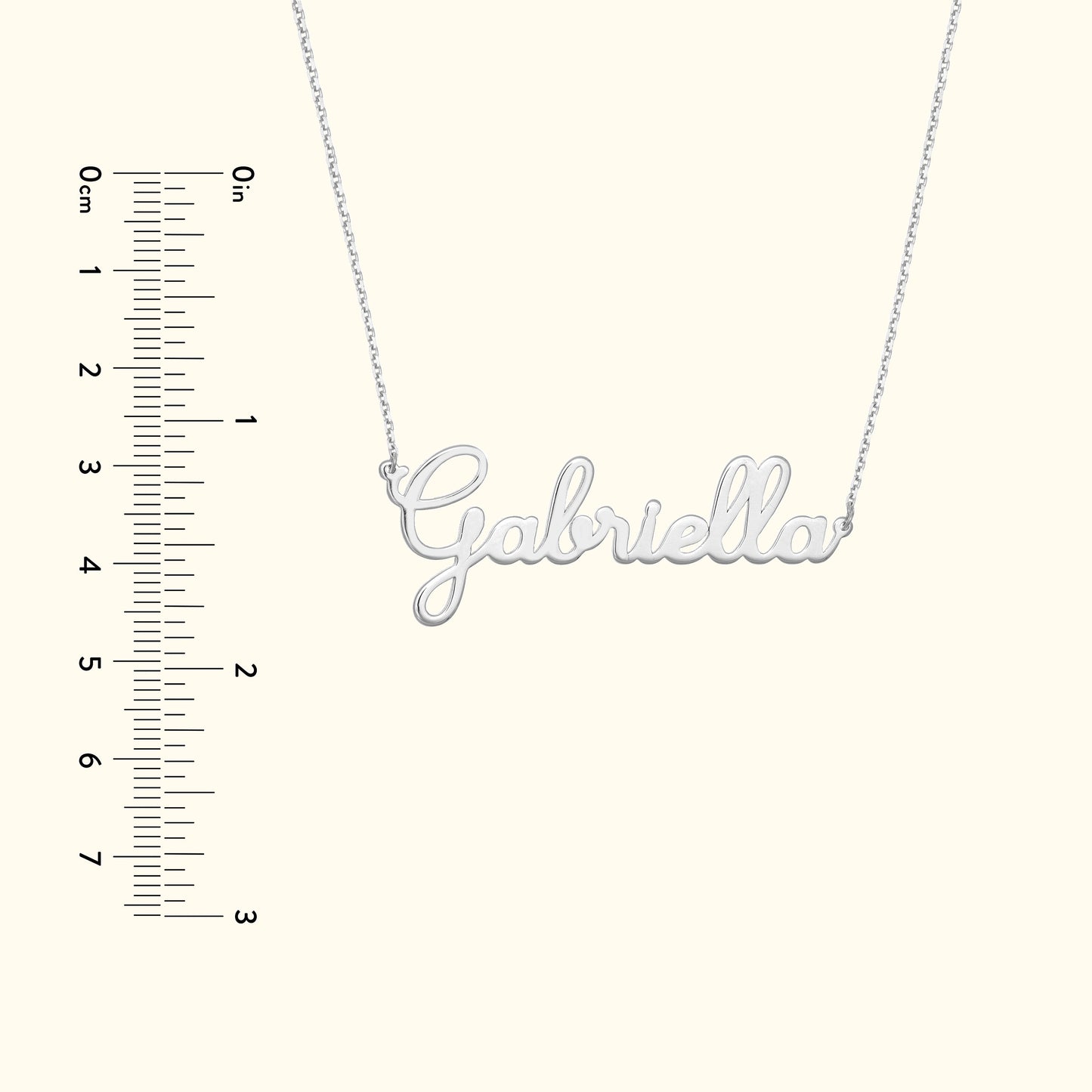 Silver name necklace spelling "Gabriella" with a ruler alongside for size reference.