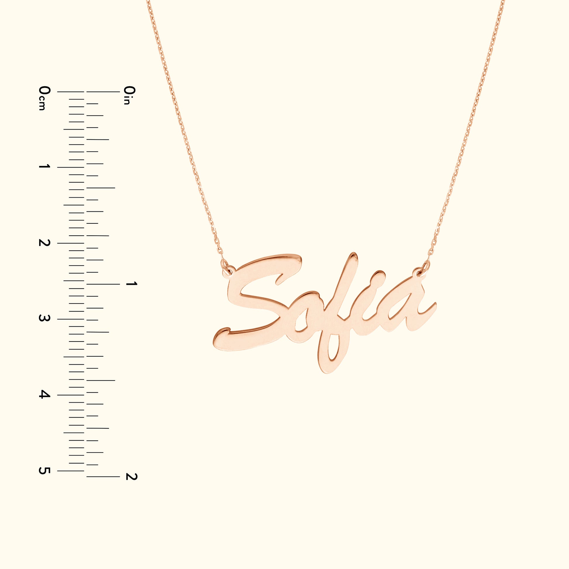 Rose gold necklace featuring the name "Sofia," with a ruler for size reference.