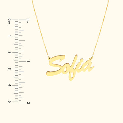 Gold necklace with the name "Sofia" in a cursive font, alongside a ruler for size reference.