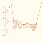 Rose gold name necklace reading "Hailey," alongside a ruler for size reference.