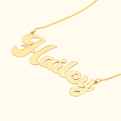 Gold name necklace spelling "Hailey" with a delicate chain.