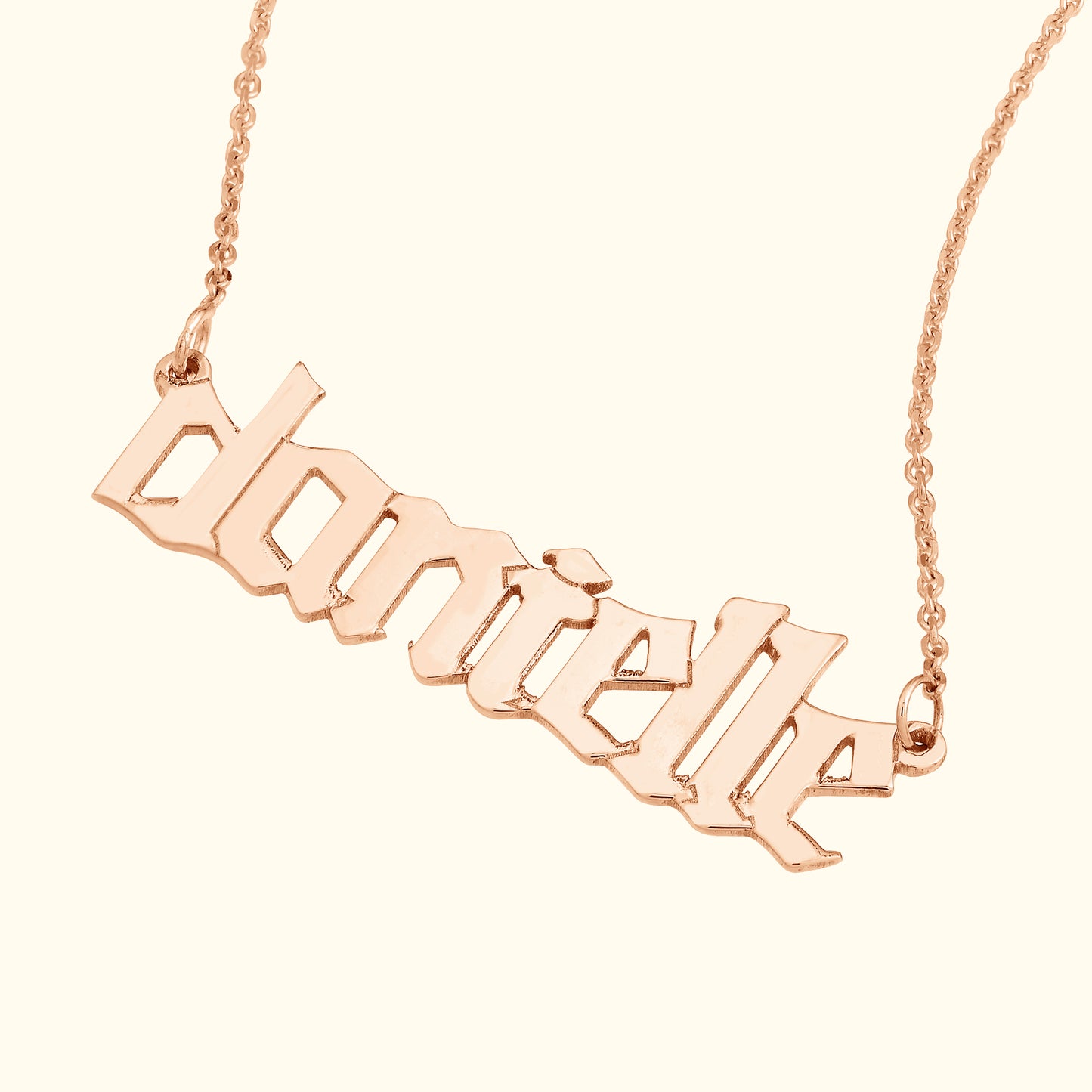 Rose gold necklace featuring a stylized nameplate with the name "danielle."