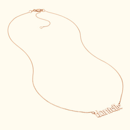 Rose gold necklace with a decorative cursive name pendant.