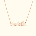 Rose gold name necklace featuring the name "danielle" in ornate lettering.