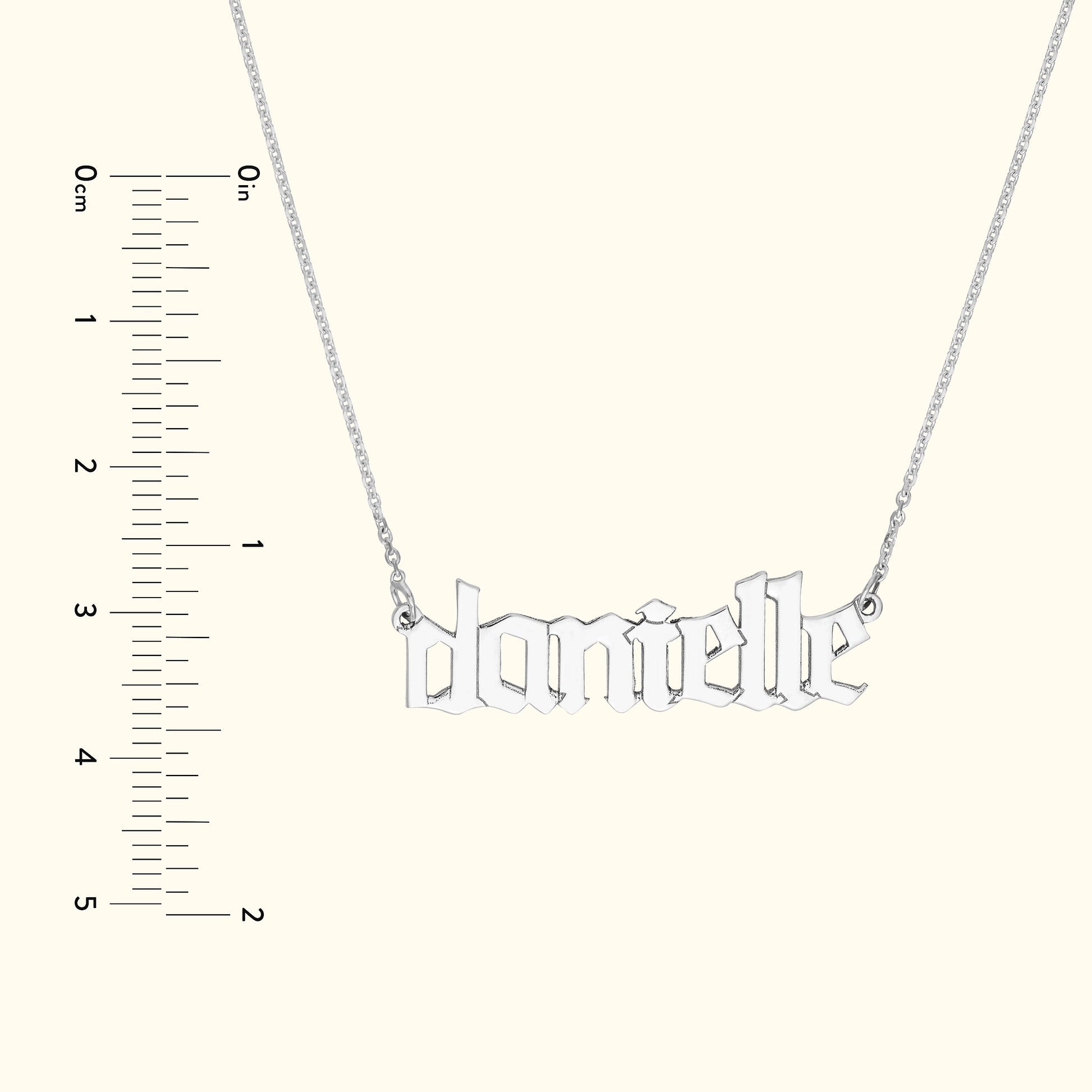 Silver necklace featuring the name "danielle" in a stylized font.