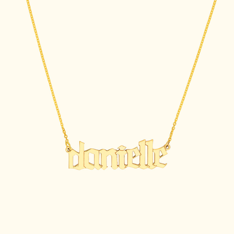 Gold name necklace featuring the name "danielle" in a stylized font.