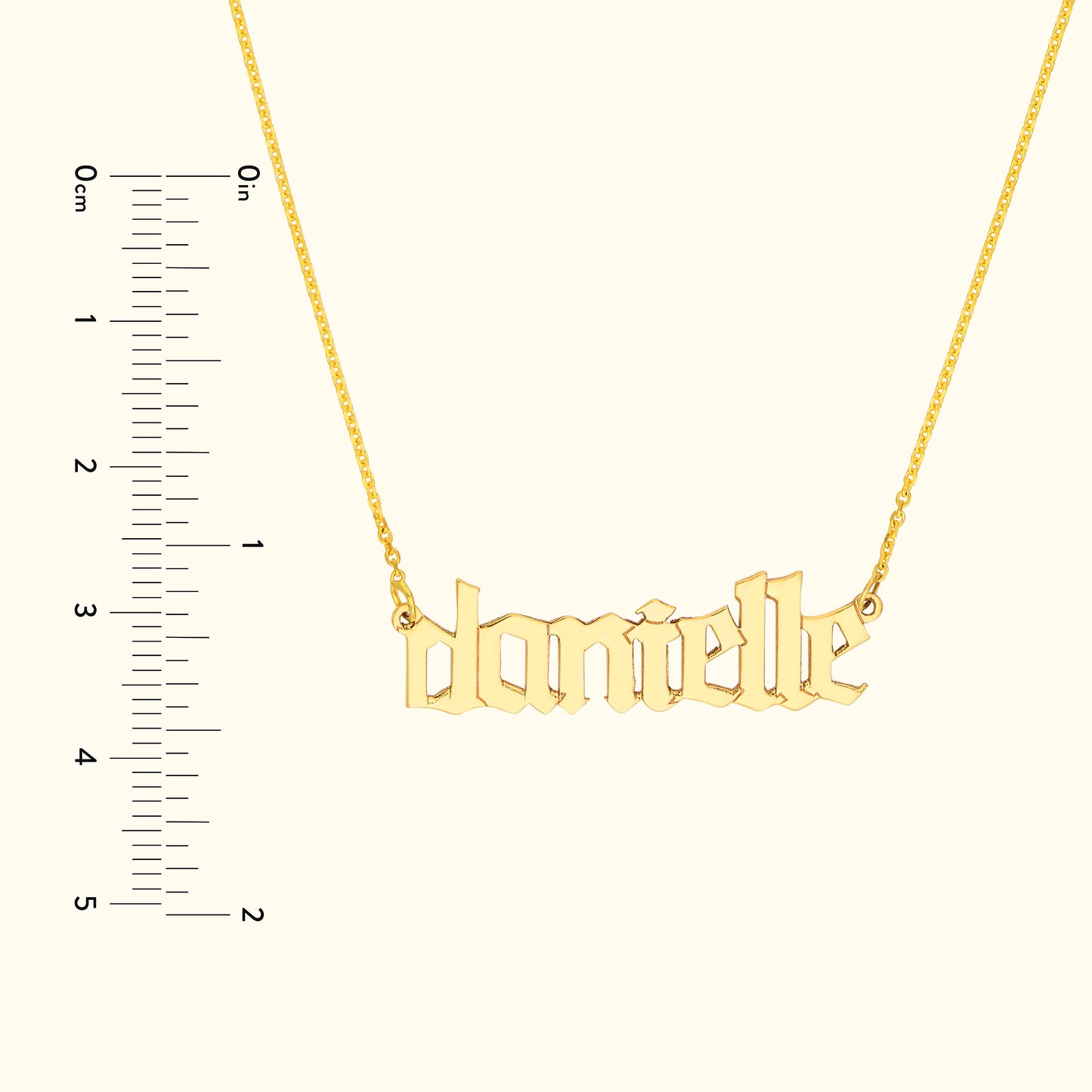 Gold name necklace featuring the name "danielle," with a measuring ruler on the side.