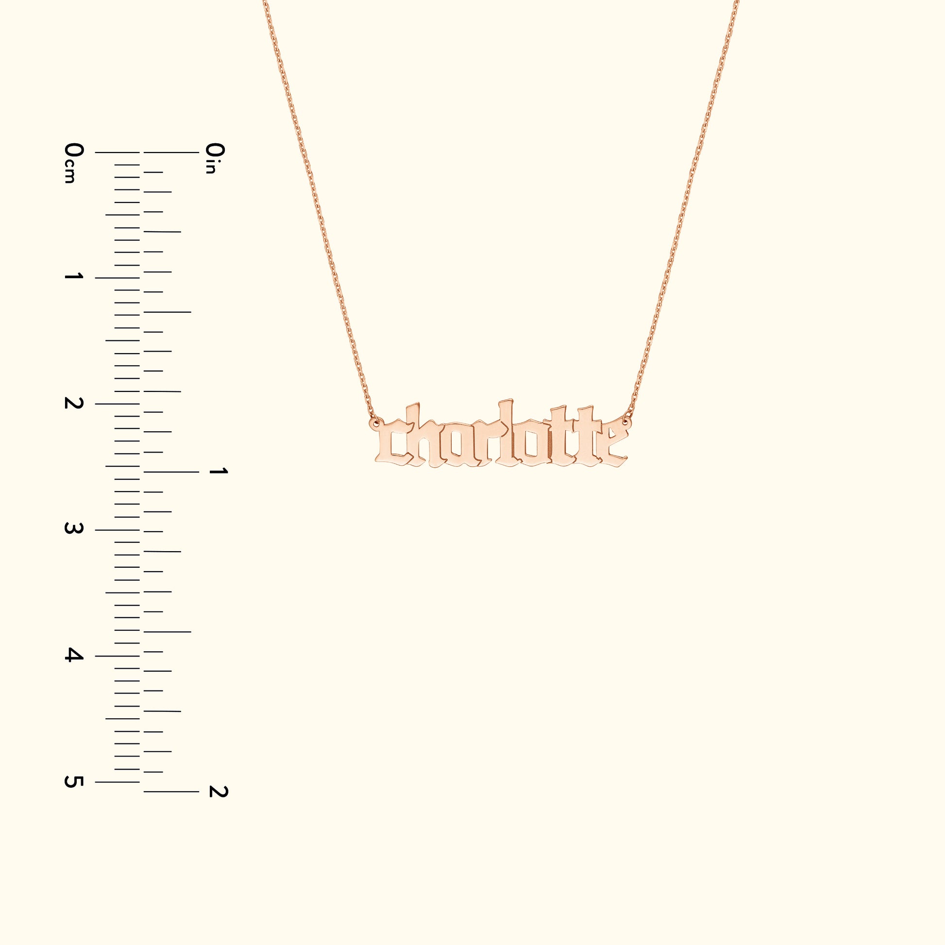 Rose gold name necklace with the word "charlotte," alongside a measurement scale.