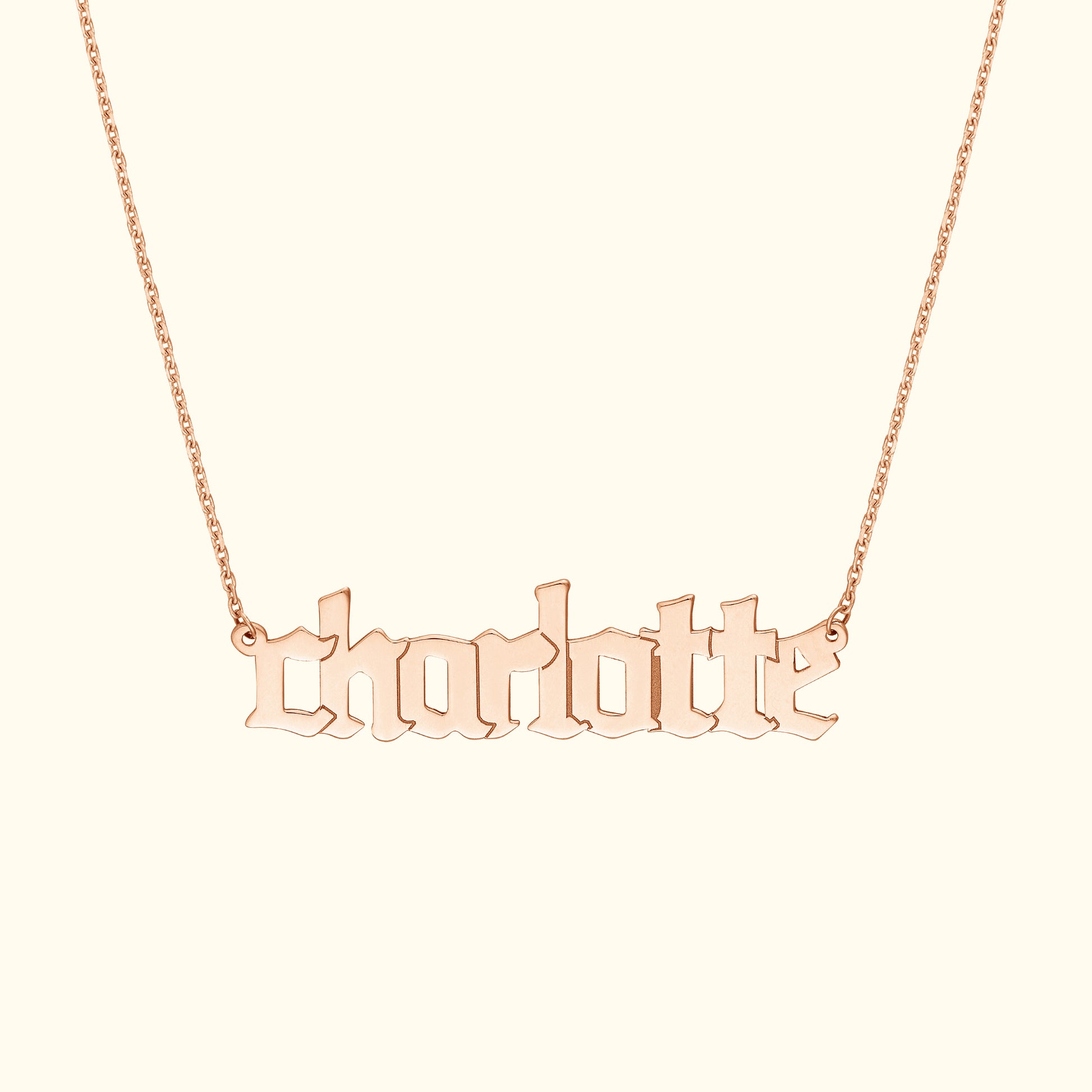 Rose gold necklace featuring the name "charlotte" in stylized lettering.