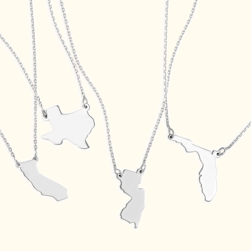 Silver necklaces featuring state-shaped pendants.