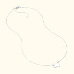 Delicate silver necklace with a small bird pendant.