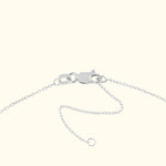Close-up of a silver necklace clasp and chain on a neutral background.