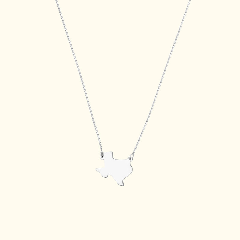 Silver necklace featuring a Texas-shaped pendant on a delicate chain.