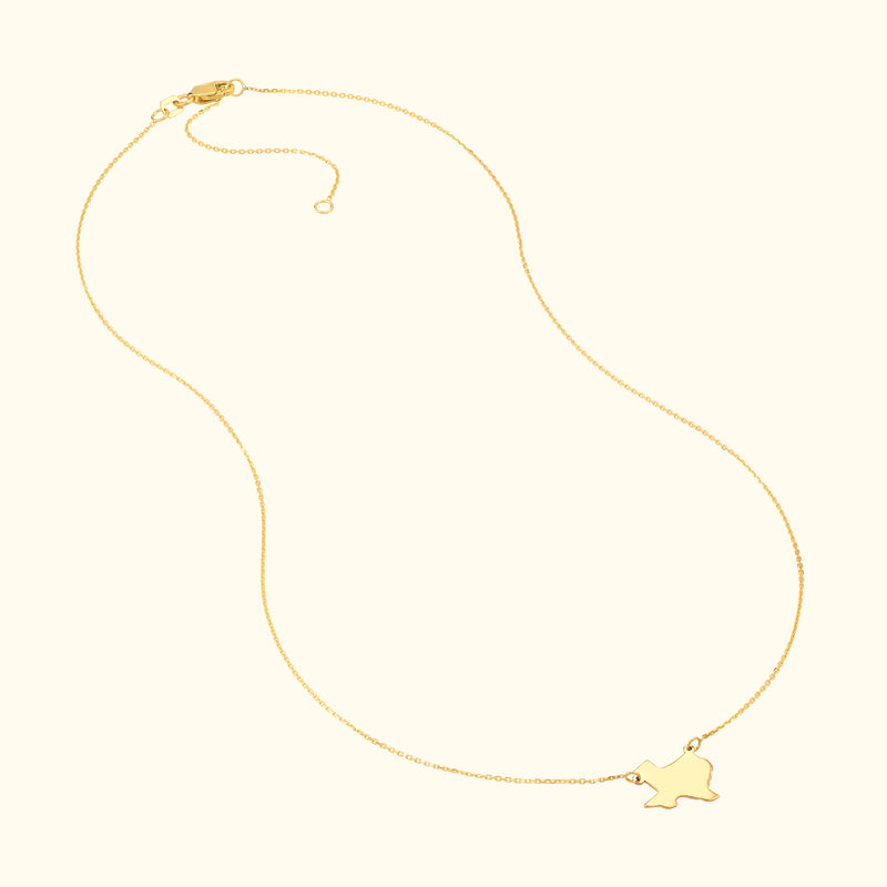 Gold necklace with a delicate chain and a small charm in the shape of a bird.