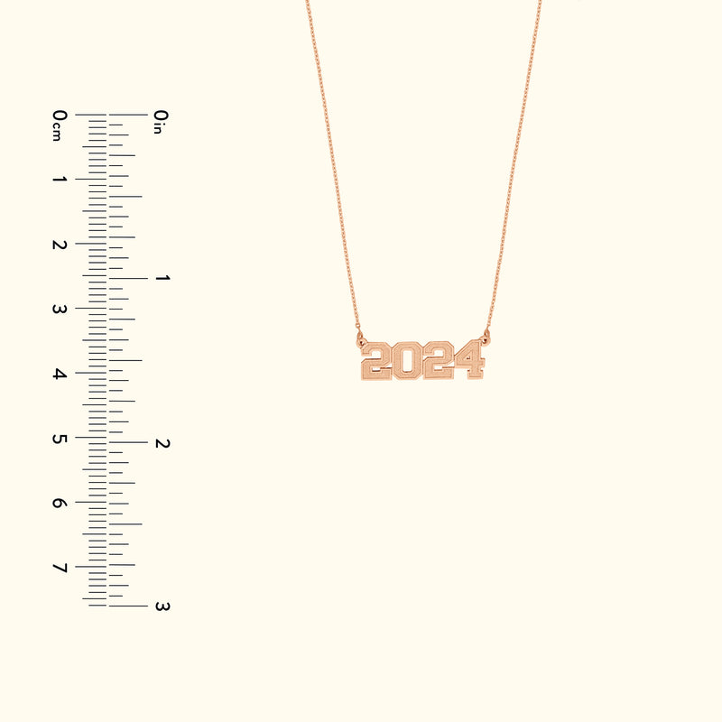 Rose gold necklace featuring the year "2024" as a pendant.