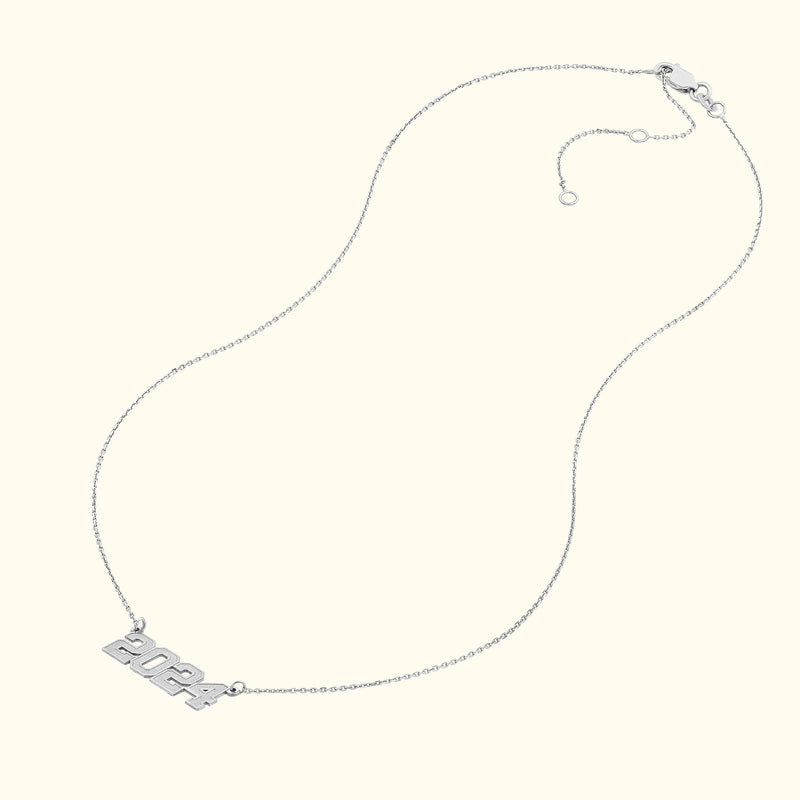 Silver necklace featuring a "2024" pendant on a delicate chain.