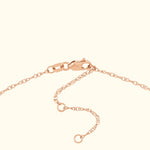 Close-up of a delicate rose gold chain with a clasp and adjustable length.