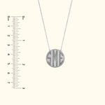 Silver pendant necklace with engraved initials "SME" on a delicate chain.