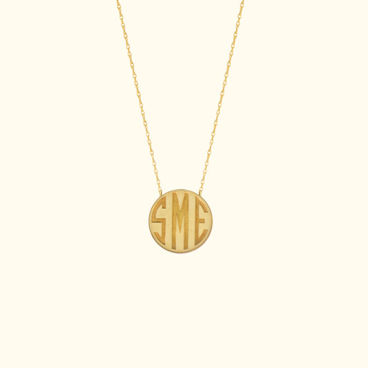 Gold pendant necklace featuring the initials "SME" in a circular design.