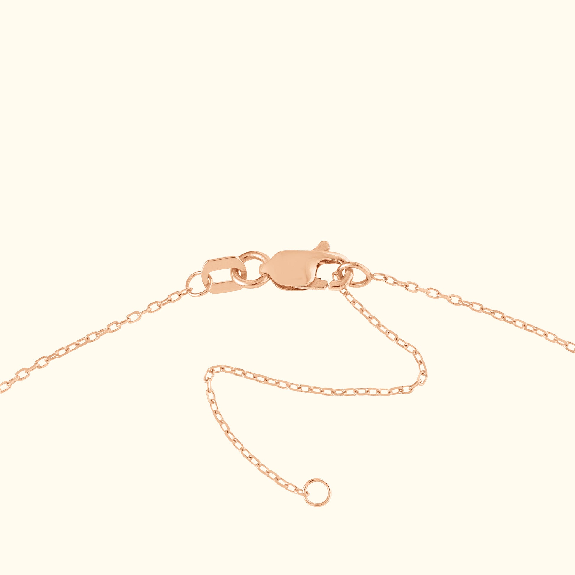 Close-up of a rose gold chain with a lobster clasp and chain extension.