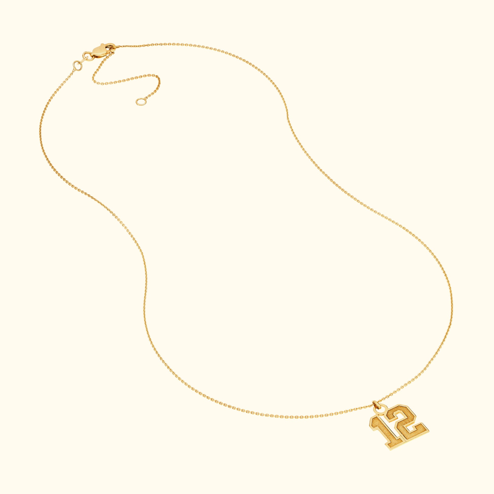 Gold necklace featuring a pendant with the number "12".