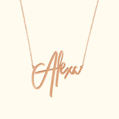 Rose gold necklace featuring a cursive name pendant reading "Alexa."