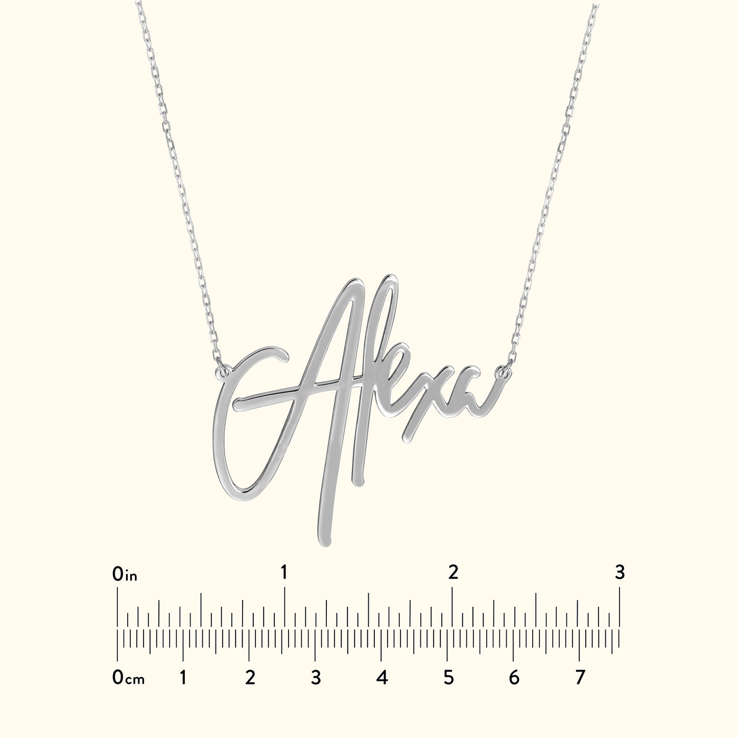 Silver name necklace with the text "Alex" displayed, accompanied by a ruler for size reference.