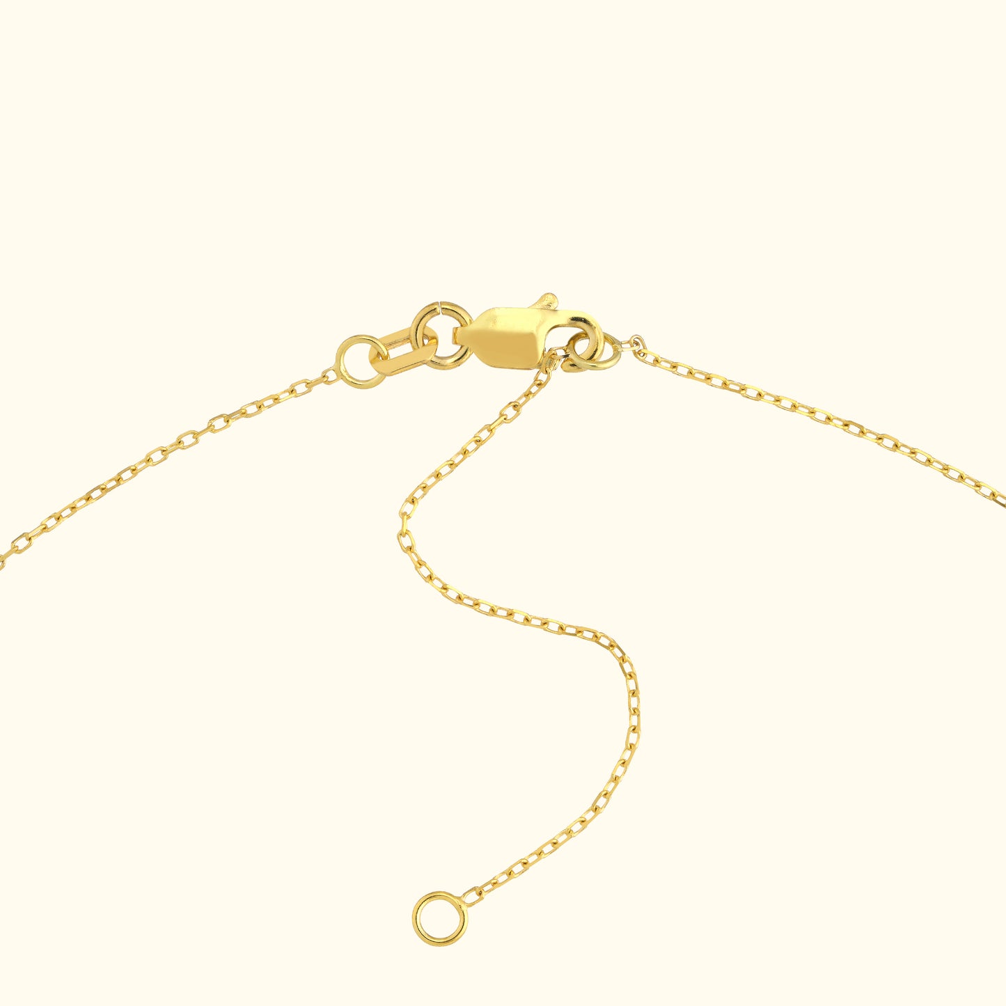 Close-up of a gold necklace chain with a clasp and loose link.