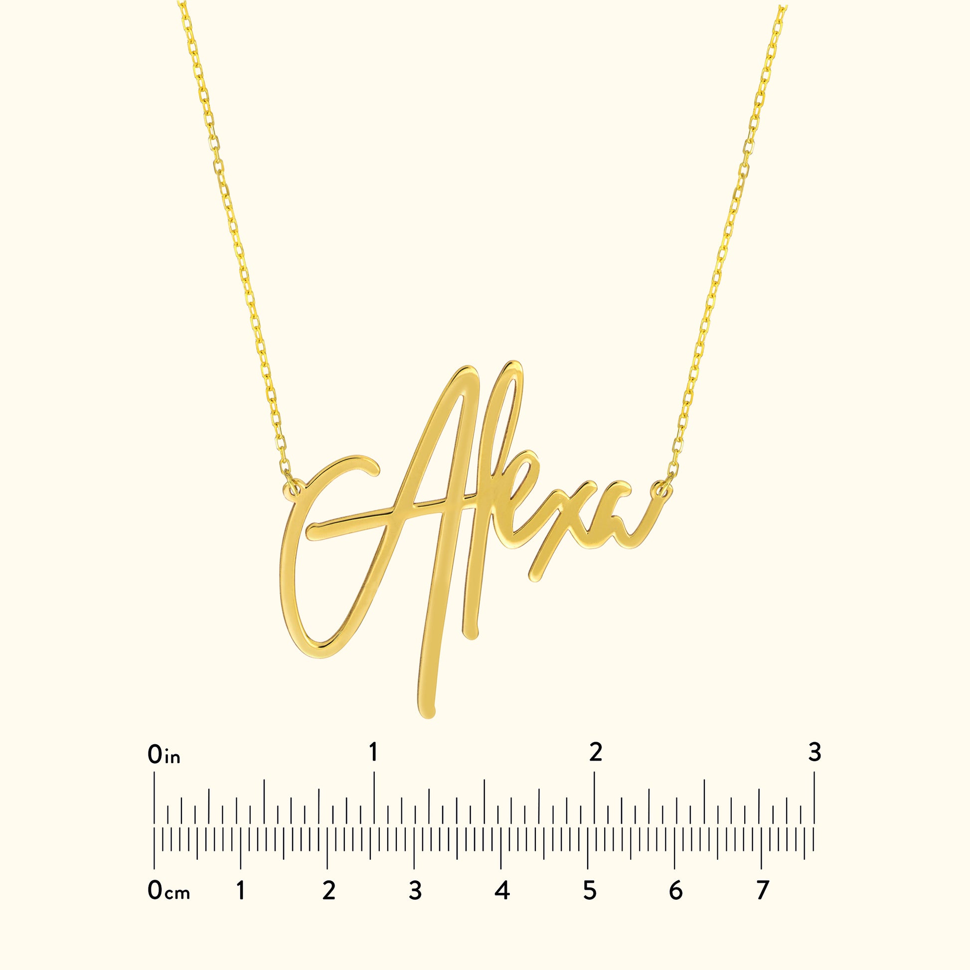 Gold necklace featuring a custom cursive name pendant "Alexx" on a light background.