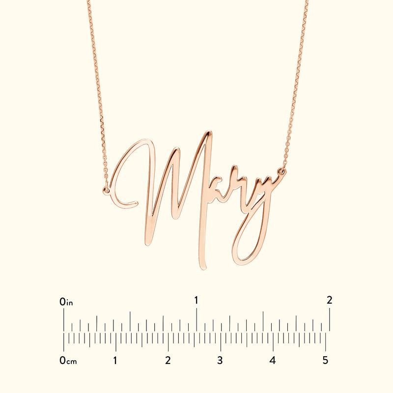Rose gold name necklace reading "Mary" with a measuring scale below.