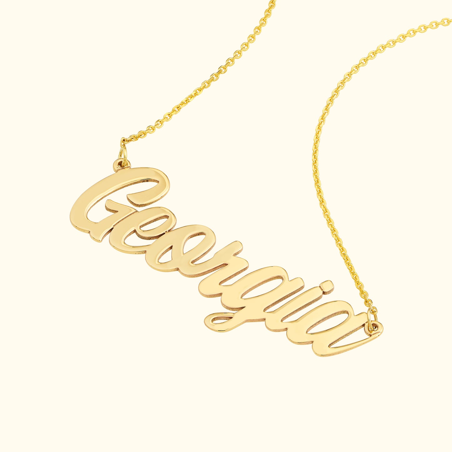 Gold name necklace with the word "Georgia" in a flowing cursive font.