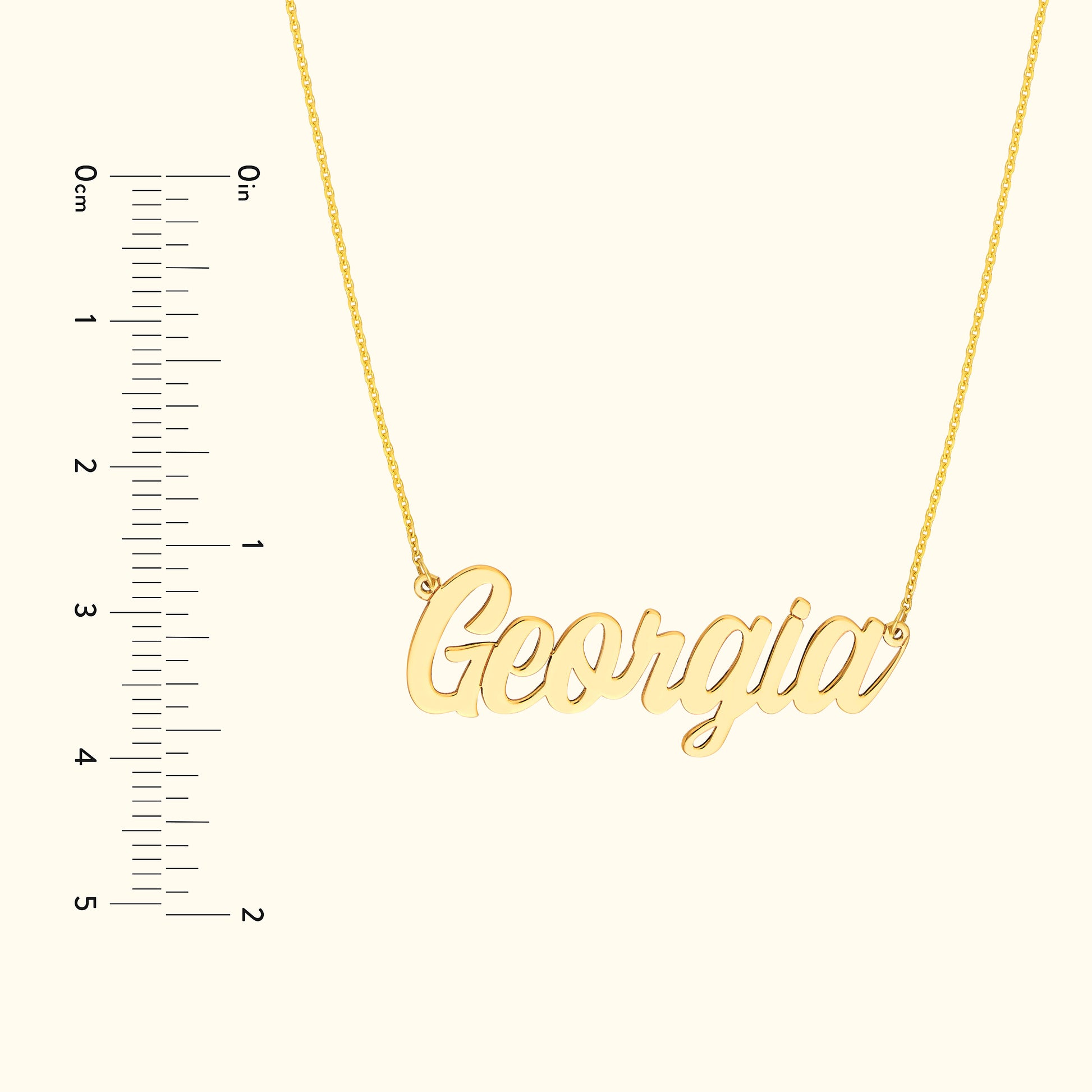 Gold name necklace reading "Georgia" alongside a ruler for size reference.