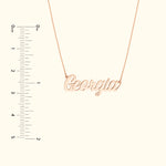 Rose gold name necklace displaying the word "Georgia", with a ruler for size reference.