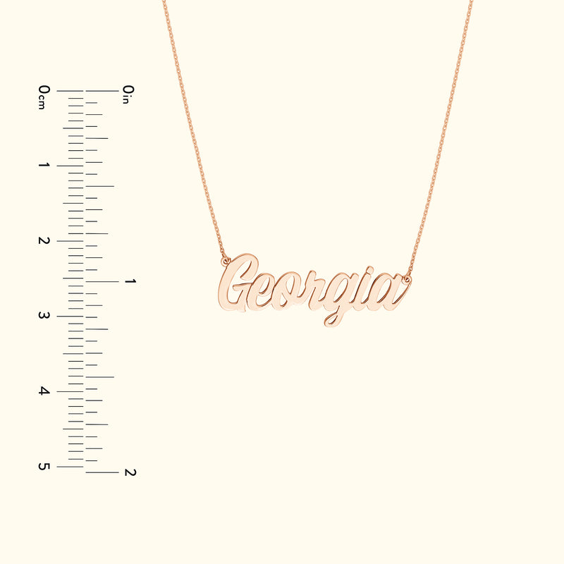 Rose gold name necklace displaying the word "Georgia", with a ruler for size reference.