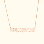 Rose gold name necklace featuring the word "cameron" in a playful font.