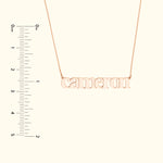 Rose gold name necklace with the word "cameron," displayed against a light background.