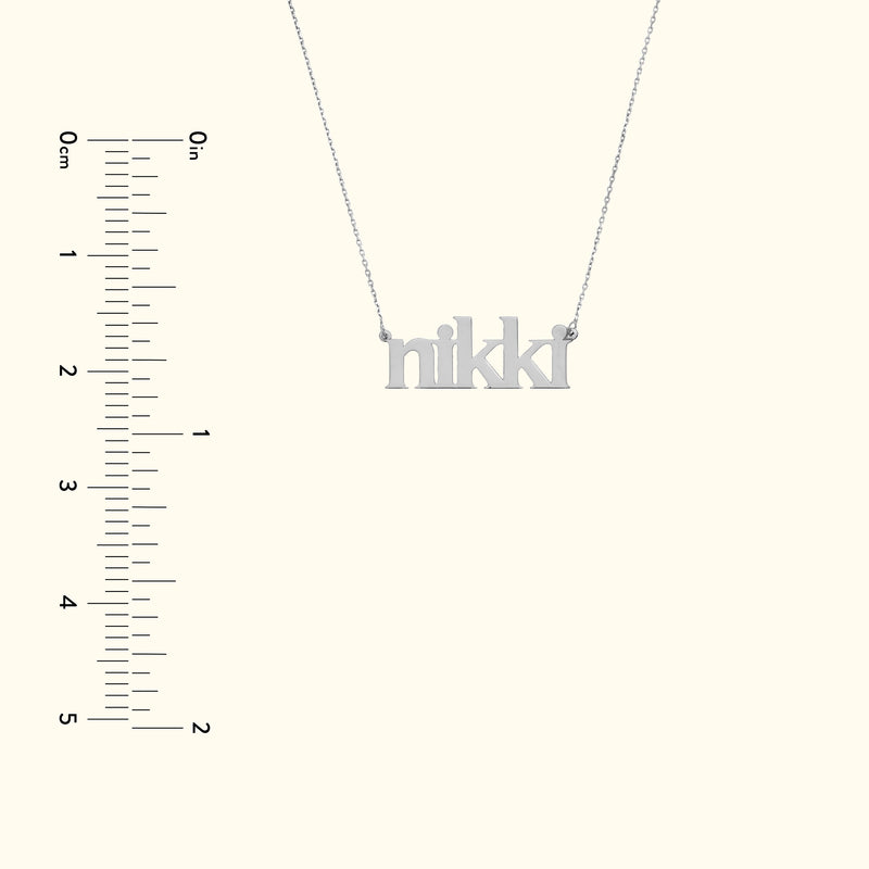 Silver name necklace spelling "nikki" with a simple chain against a light background.