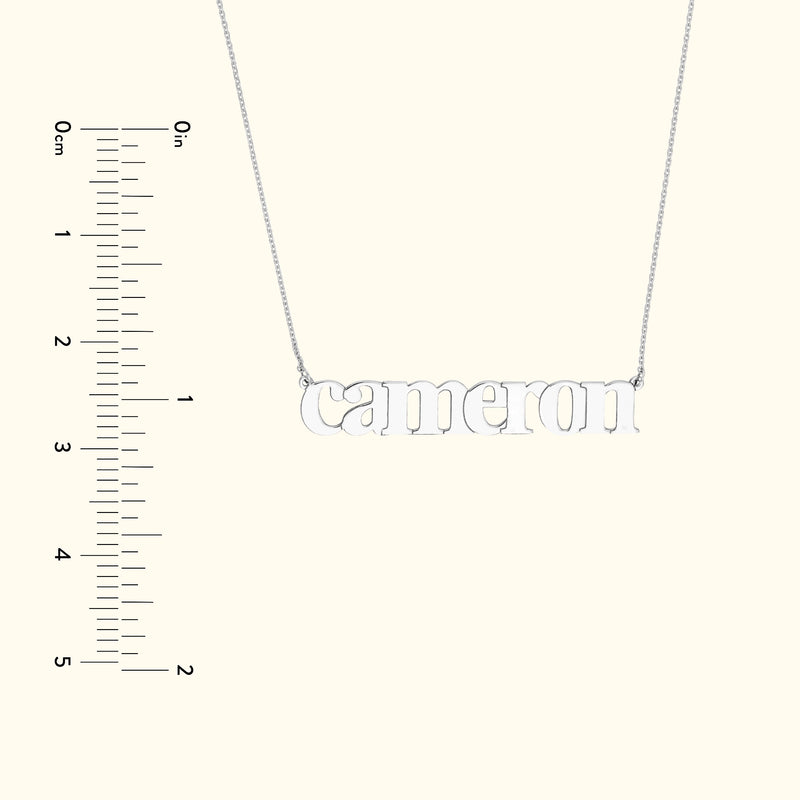 Silver name necklace spelling "Cameron" on a simple chain, with a measuring scale on the side.