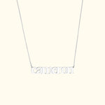 Silver name necklace reading "cameron" on a delicate chain.