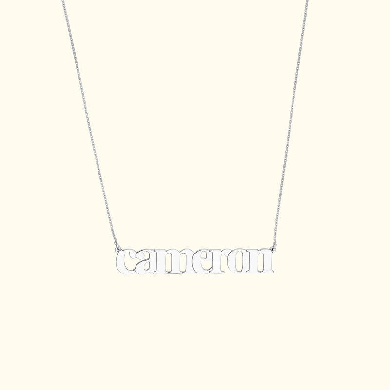 Silver name necklace reading "cameron" on a delicate chain.