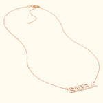 Gold name necklace with the word "ISABELA" in bold, elegant lettering.