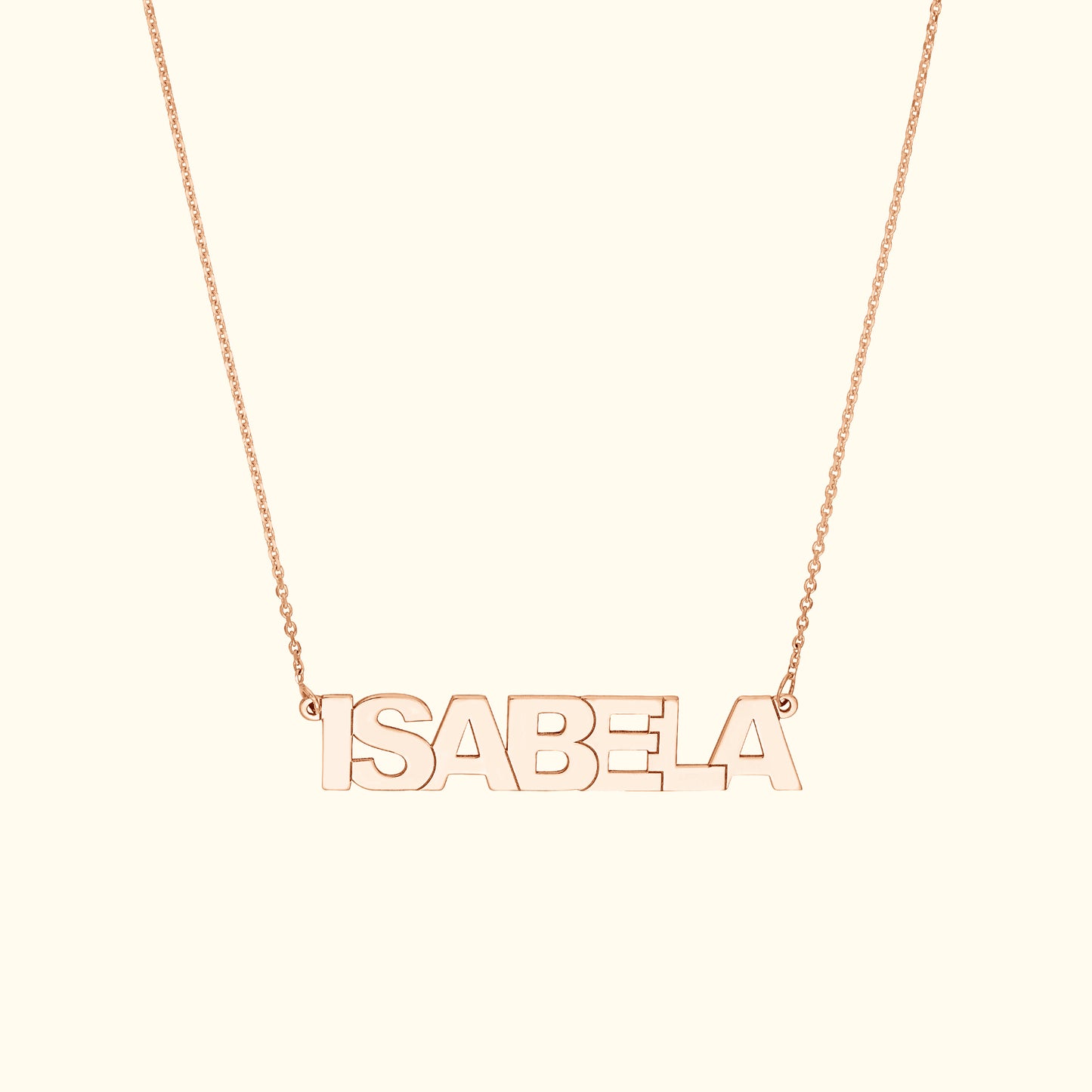 Rose gold name necklace spelling "ISABELA" on a delicate chain.