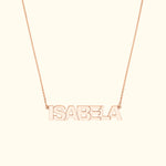 Rose gold name necklace spelling "ISABELA" on a delicate chain.